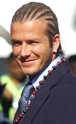 David Beckham com trancinhas, brincos de argola de diamante e um colar de contas